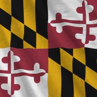 Maryland US state flag with big folds waving close up under the studio light indoors. The official symbols and colors in fabric banner